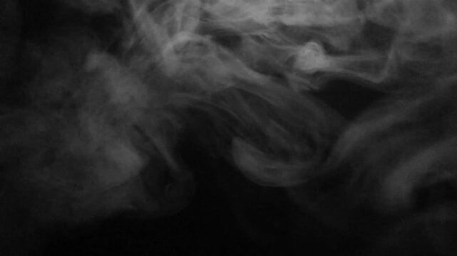 Wisps of white smoke drift and swirl creating abstract patterns against a dark background.