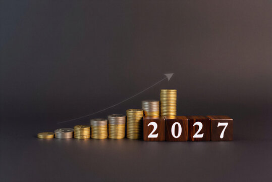 2027 financial growth concept with stacked coins and wooden blocks on dark background