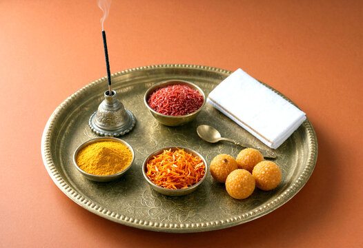 Traditional metal tray with incense burner turmeric saffron and sweets for religious ritual setup
