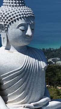 Big Buddha of Phuket fills frame in close detail against deep blue Andaman Sea, aerial tracking right backdrop
