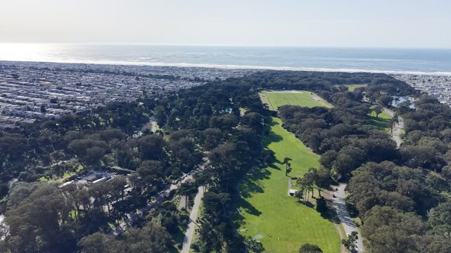 Aerial view of Golden Gate Park, San Francisco, with green fields, dense neighborhoods and the Pacific Ocean. g.