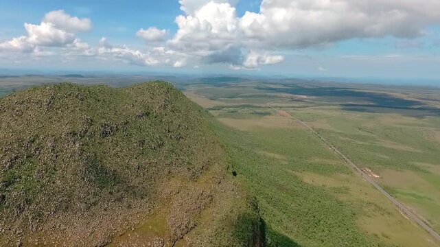 Morro da Baleia rises above GO-239 in Alto Paraiso de Goias, Goias, Brazil, South America, overlooking the vast Chapada dos Veadeiros plateau and Cerrado, drone forward flyover.