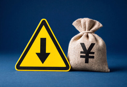 Warning sign with downward arrow next to a money bag with yen symbol on blue background