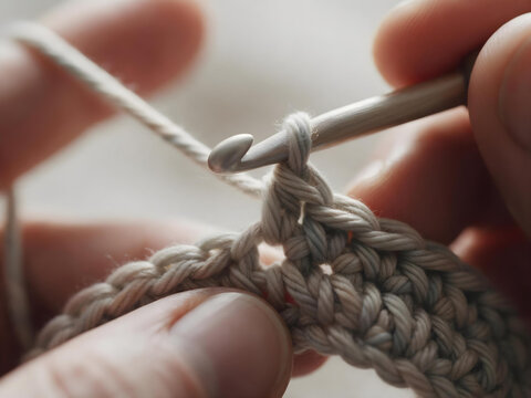 A photorealistic extreme close-up of hands mid-embroidery