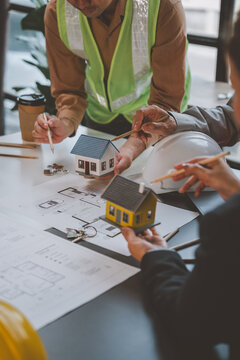 Real estate agents discussing house project blueprint