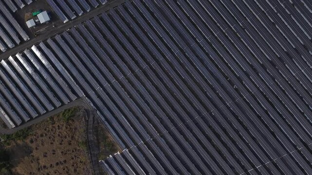 Aerial Drone Flight Over Rows of Solar Panels.