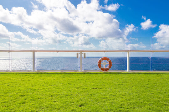 Orange lifebuoy on a deck of cruise ship with ocean on background with blue sky and copy space