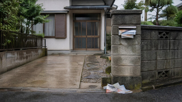 Mailbox overflowing with flyers at the entrance of a Japanese house