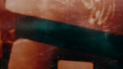 Fototapeta na wymiar Abstract vintage film grain texture with dust and scratches, dark background with warm red and orange light leak.