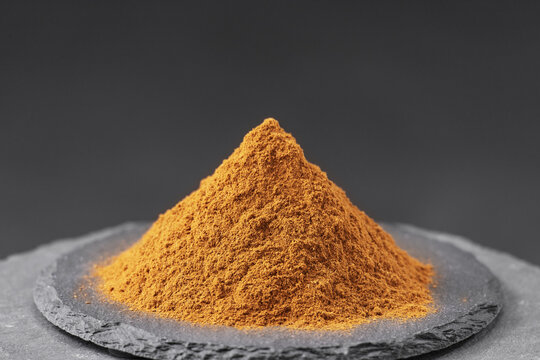 powder from dried clove buds, Syzygium aromaticum tree on a black slate stone tray