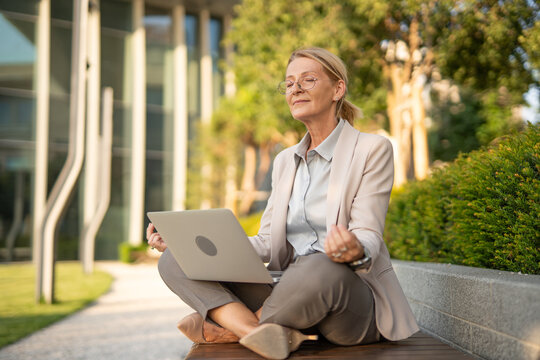 Businesswoman meditating outdoors finding work life balance