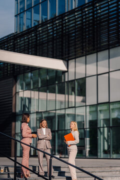 Business women communicating outdoors a modern office building
