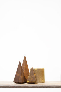 Minimalist three wooden cone trees and shimmering golden bokeh. Warm, earthy holiday aesthetic suitable for boutique sales, social media ads, and winter-themed graphic design.