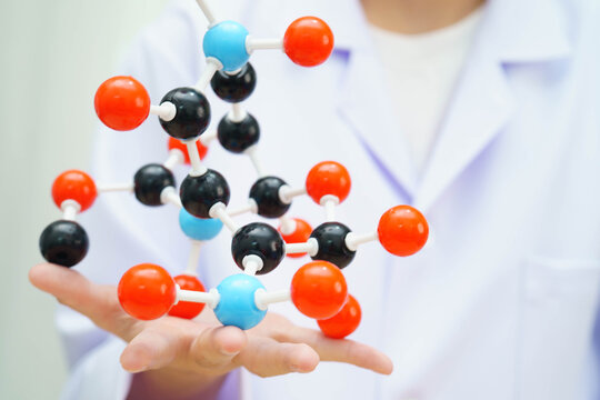 Scientist holding molecular model for chemical technology.