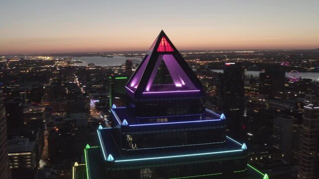 Place Ville Marie&rsquo;s pyramid roof cycles through colorful LED bands as a drone circles above the city at night.