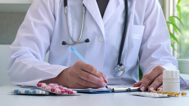 Female doctor writing prescription at office. Many different medicines on the table. Healthcare, medical and pharmacy industry concept