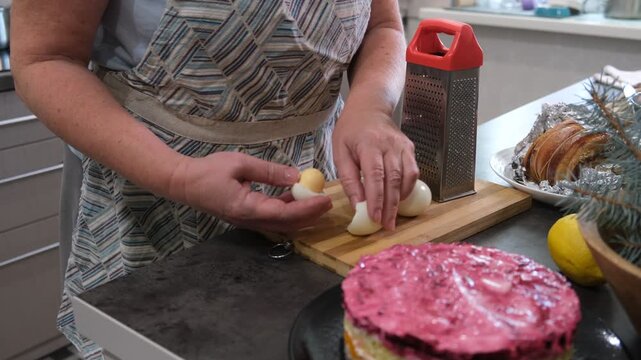 Preparing a traditional family salad. Grating eggs.