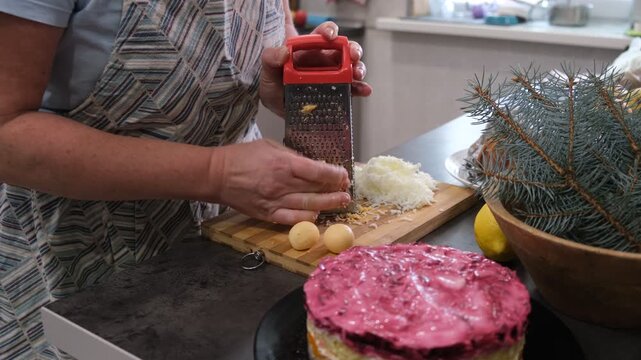 Preparing a traditional family salad. Grating eggs.