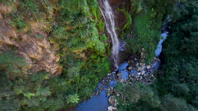 Aerial View of Waterfall Cascading into Rainforest Creek