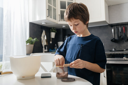 Young boy learning cooking skills in home kitchen