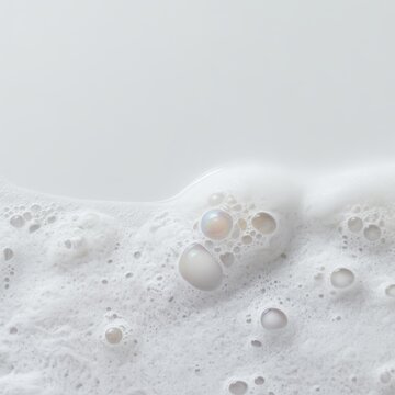 Soft soap foam and bubbles glowing under studio lighting against a clean white background. Perfect for cosmetics and skincare product advertisements.