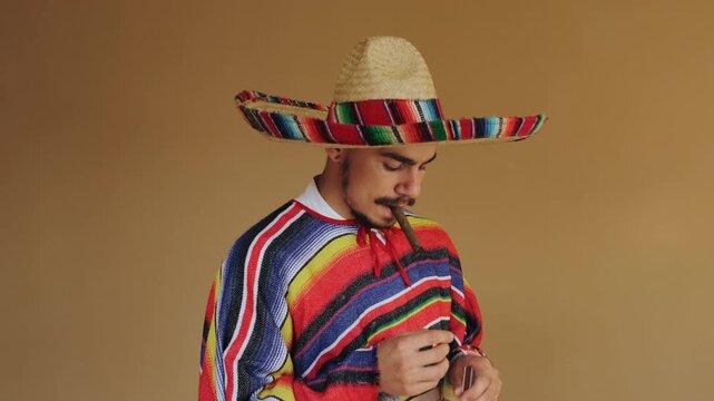 Young man wearing wide-brim woven straw sombrero with multicolor band and matching striped serape poncho lights cigar with handheld lighter, with sombrero, poncho, cigar, lighter detail