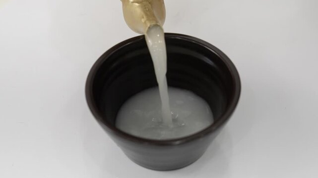 Close-up Fixed Shot of Pouring Traditional Korean Rice Wine Makgeolli into a Bowl (Korean Culture, Beverage)