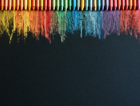 Crayons arranged in a row melting and blending colorful powder on a black surface.