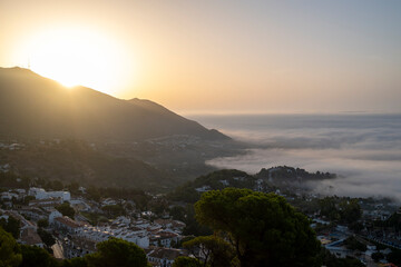 Fototapeta premium Mijas, Málaga, Spain – Mountain landscape and whitewashed village above the clouds at sunset