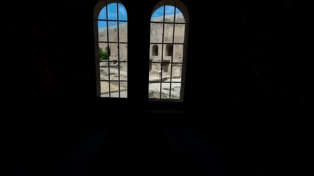 Two arched windows illuminate a dark historic stone interior in Crete, Greece, Crete, Greece