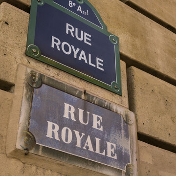 Two historic Rue Royale street signs on a building wall in Paris