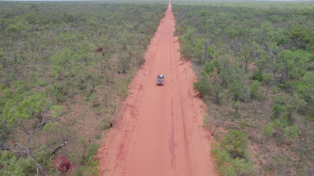 Aerial View Of A 4WD Vehicle Driving Down A Remote Red Dirt Pindan Road On The Dampier Peninsula, Western Australia.