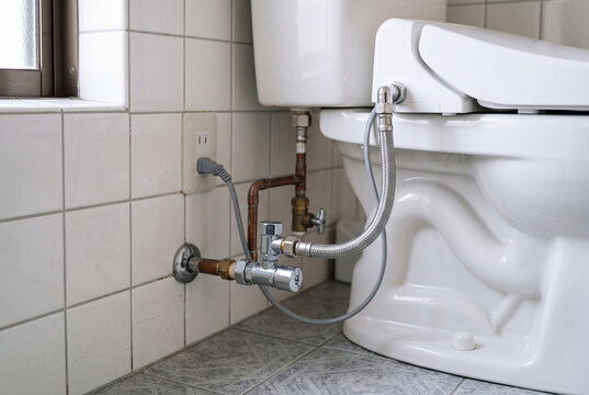 トイレ横の給水管と止水栓を写した住宅トイレの配管クローズアップ