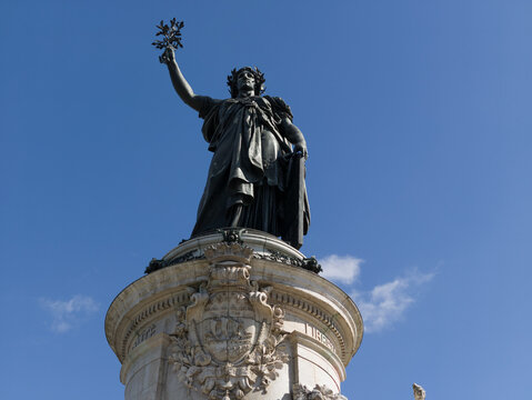 Marianne statue standing against a clear blue sky, symbolizing French liberty and democracy