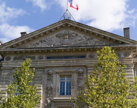 Historic Caserne Verines building facade with French flag flying under blue sky