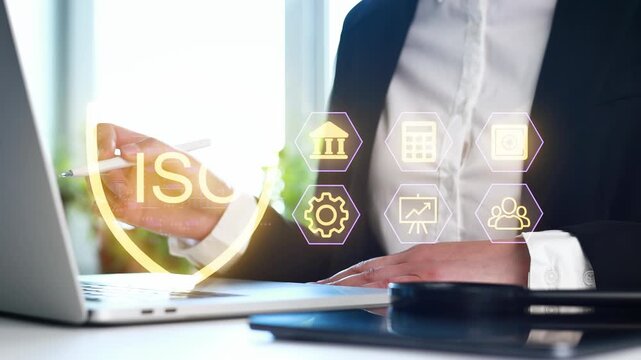 A person in a suit is using a laptop in an office setting. They are interacting with floating icons related to finance and technology. The scene shows the integration of digital tools in work.