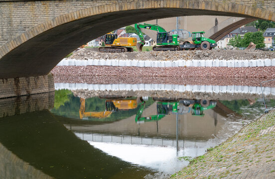Construction site, excavators and road roller, temporary bank reinforcement, sandbags and crushed stone, bridge Wasserbillig, Luxembourg