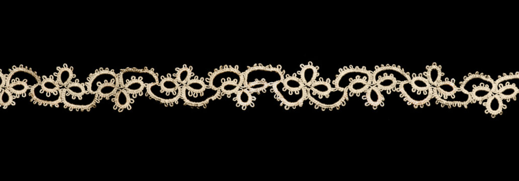 Tatting lace frivolite tape isolated on black background, top view,  handmade. gimp trim, vintage textile design, antique fabric art, needlework
