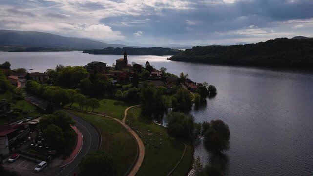 Drone view of "Uribarri Ganboa" village surronded by a reservoir with the same name in Araba, at the Basque Country.