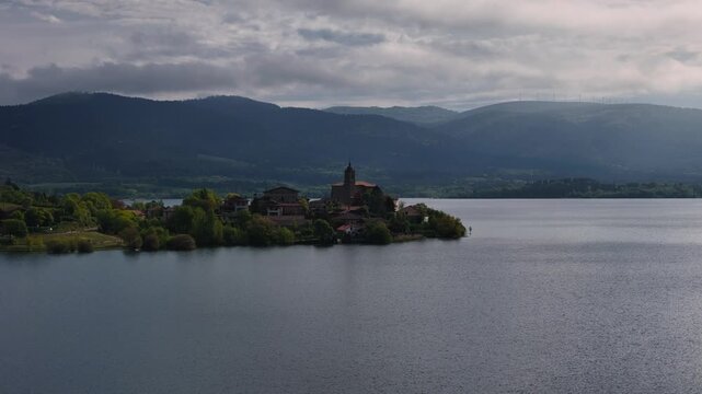 Drone view of "Uribarri Ganboa" village surronded by a reservoir with the same name in Araba, at the Basque Country.