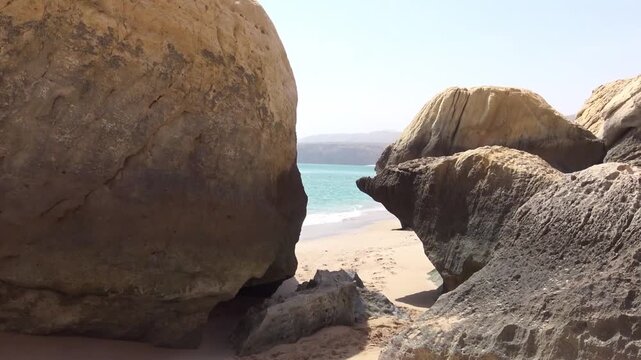 Sculpted rock formations framing a turquoise cove on the Omani coast