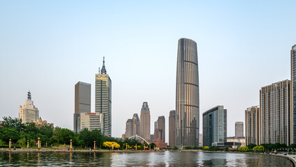 Fototapeta premium Modern City Skyscrapers Along Waterfront Under Clear Sky