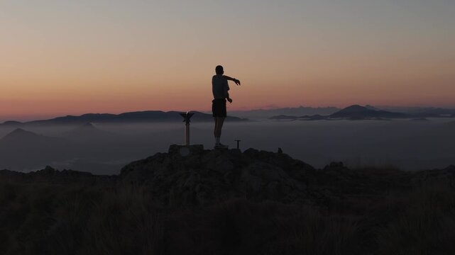 Man hiking and running on the top of the mountains at sunset time, at the Basque Country.
