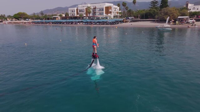 Woman Taking Off on a Flyboard and Splashing Back into the Sea near Kalamata Beach, Greece, Aerial View