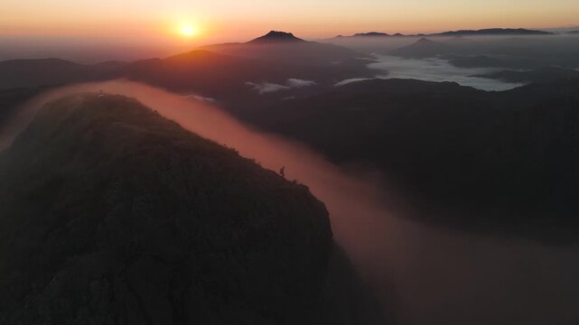 Man hiking and running on the top of the mountains at sunset time, at the Basque Country.