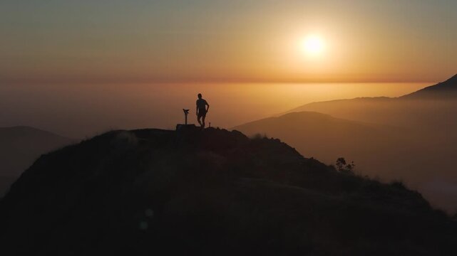 Man hiking and running on the top of the mountains at sunset time, at the Basque Country.