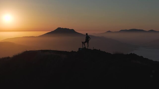 Man hiking and running on the top of the mountains at sunset time, at the Basque Country.