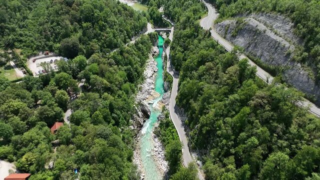 Aerial top down perspective captures turquoise Soca river crystal clear water. rocky canyon banks surrounded by dense wild green forest near Kobarid.