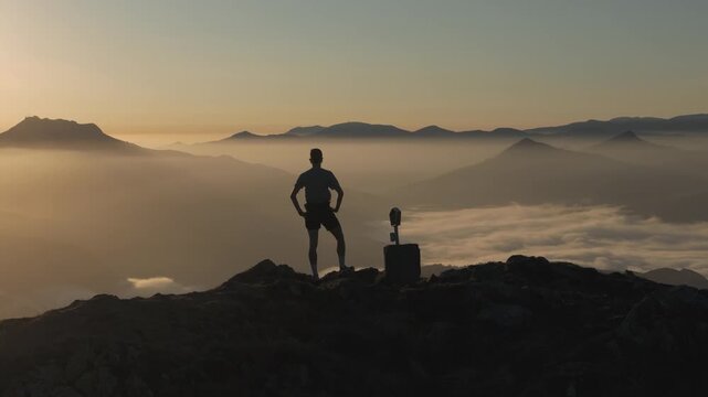 Man hiking and running on the top of the mountains at sunset time, at the Basque Country.