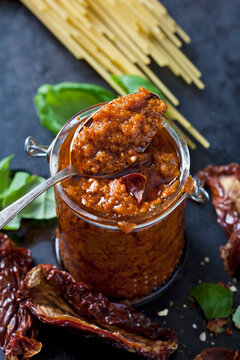 Spoon and glass of tomato pesto